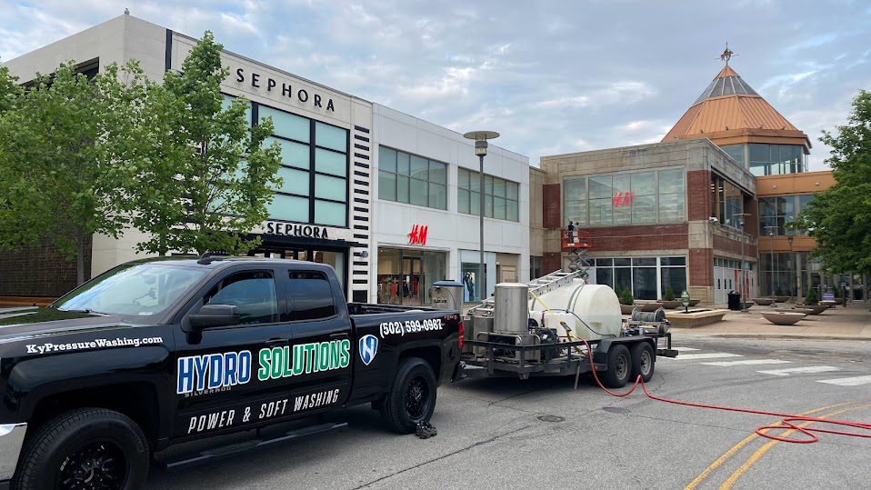 Hydro Solutions power washing truck in front of Sephora and H&M.